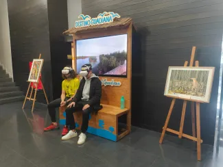 Dos visitantes disfrutan de los vídeos 360º de la cuenca del Guadiana gracias a las gafas de realidad virtual.